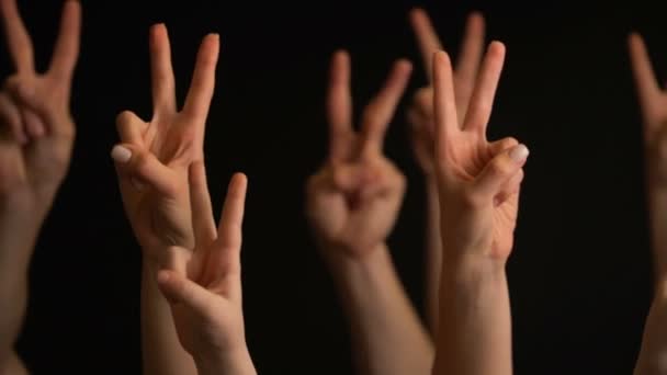 Handen aantrekken met overwinnings gebaar op zwarte achtergrond. - Video