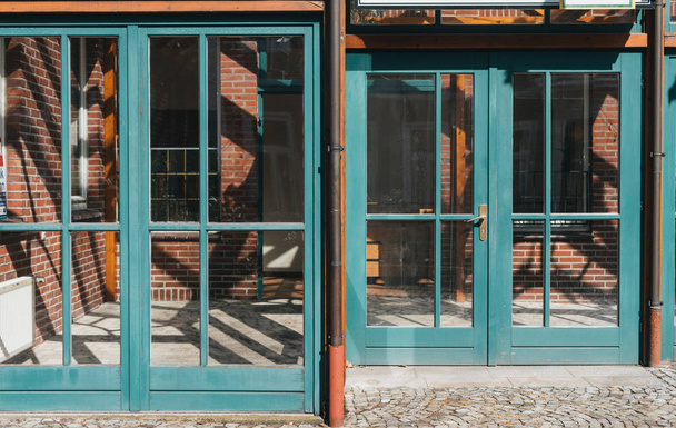 Skleněná okna a dveře s tyrkysovou rámy v červeném - Fotografie, Obrázek