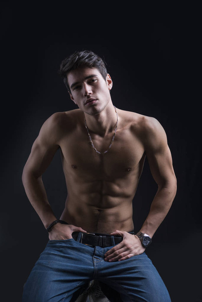 Handsome muscular shirtless young man kneeling down on the floor confident, looking at camera - Photo, image