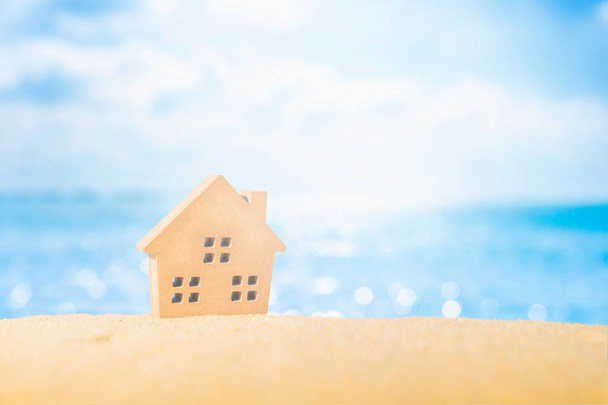 Closed up tiny home models on sand with sunlight and beach. - Photo, Image