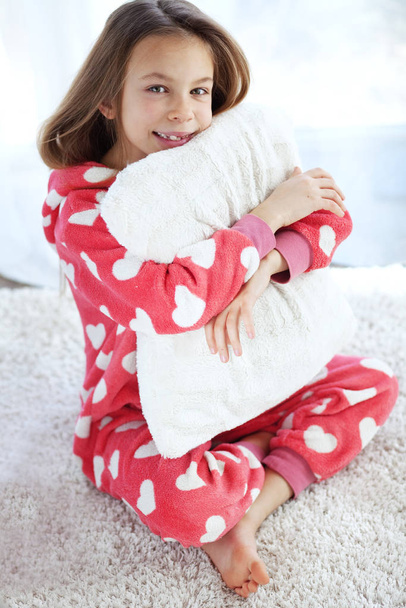 Portrait of child in soft warm pajamas sitting on the carpet at home - Fotó, kép