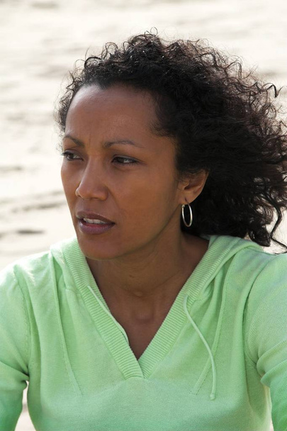 Beautiful black woman on the beach with a thoughtful look - Foto, afbeelding