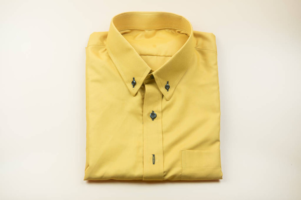 Chemises jaunes pour hommes pliées sur un fond jaune
 - Photo, image