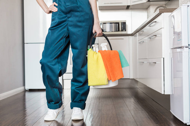 Cleaning service with professional equipment during work. professional kitchenette cleaning, sofa dry cleaning, window and floor washing. man and women in uniform, overalls and rubber gloves - Foto, Imagen