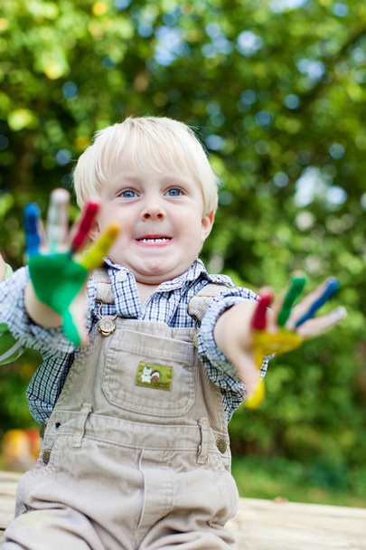 little boy showing his painted hands outside - Foto, afbeelding