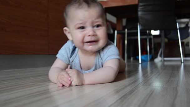 Tracking shot, schattige zes maanden oude baby jongen werd moe van buik timme beginnen te huilen - Video