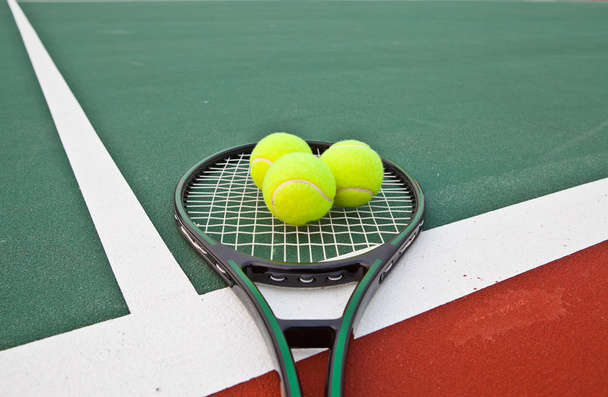 Pista de tenis con pelotas y raqueta
 - Foto, imagen