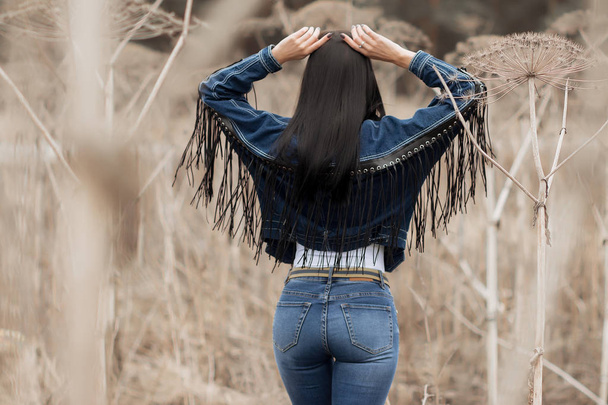 Portrait of a girl in jeans in the field - Fotoğraf, Görsel
