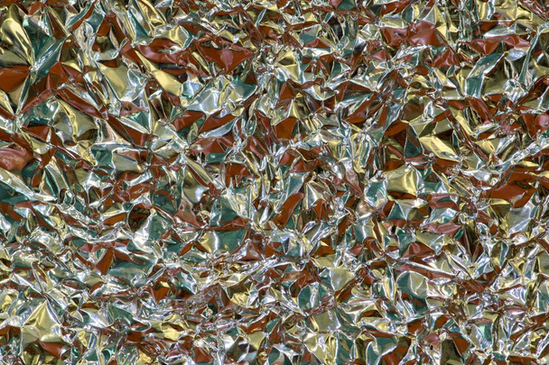 Full frame background of tinfoil that has been scrunched up and wrinkled to give it an interesting abstract texture.  - Photo, Image