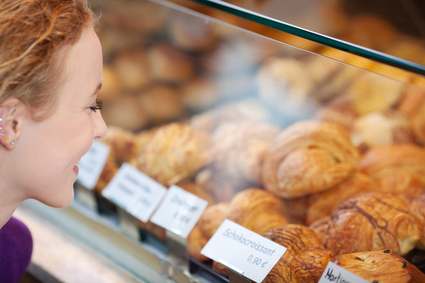 Woman Looking At Breads In Display Cabinet - Foto, immagini