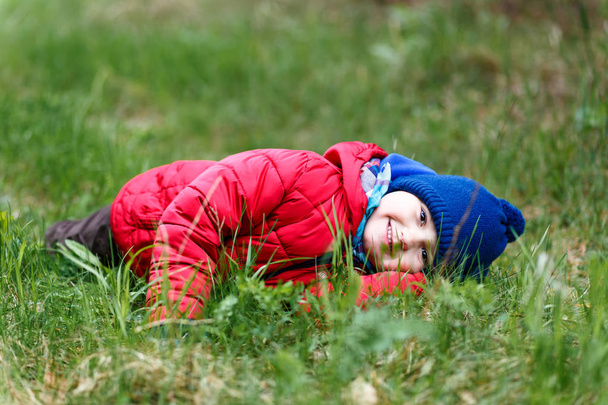 small child lying on the green grass - Foto, afbeelding