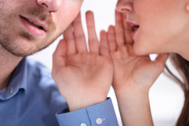 Portrait Of Happy Woman Whispering Secret Or Interesting Gossip To Handsome Man In His Ear - Foto, afbeelding