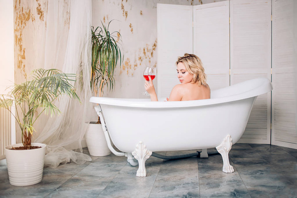 Blonde woman relaxing in bath - Фото, изображение
