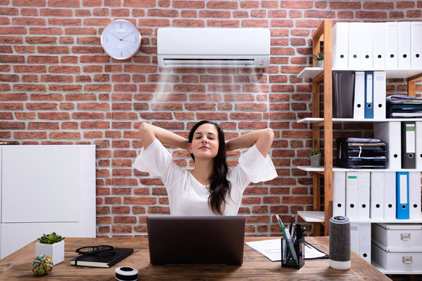 Relaxed Businesswoman Enjoying The Cooling Of Air Conditioner In The Office - Fotó, kép