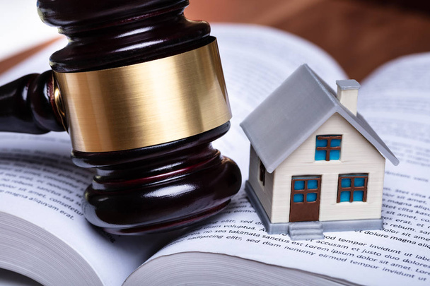Close-up Of Miniature House And Gavel On Open Book - Foto, imagen