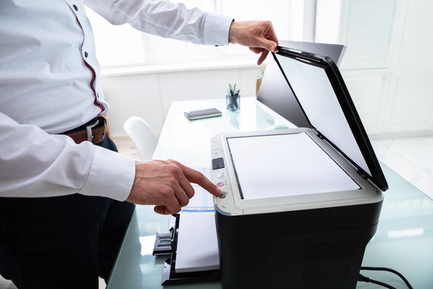 Close-up Of Businessman Pressing Printer's Button In Office - Photo, Image