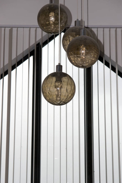four hanging ball lights from a building roof - Foto, Bild