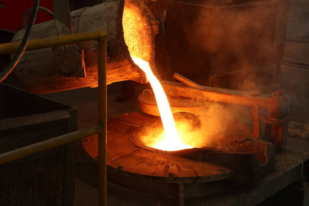 Vazamento de ferro fundido da concha para o forno de fusão
  - Foto, Imagem