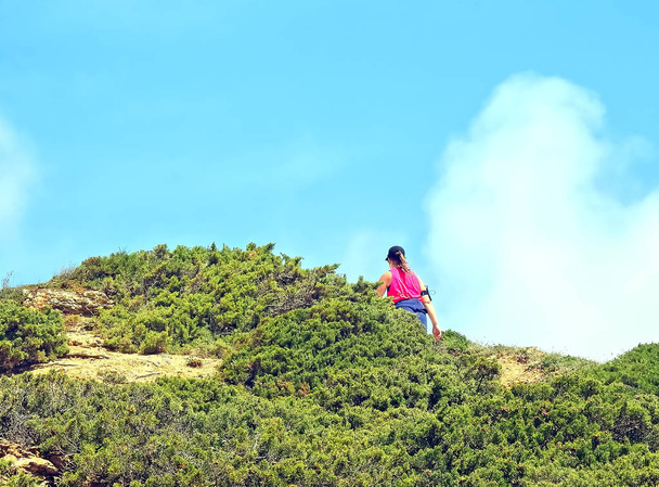 Tepenin arkasında kırmızı gömlekli bir kadın var. - Fotoğraf, Görsel