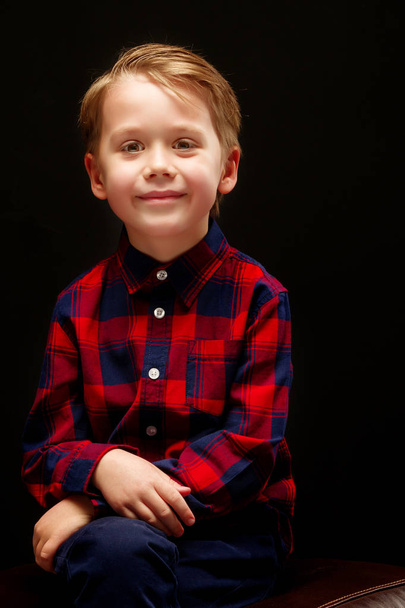 Beautiful little boy on a black background, close-up. - Fotografie, Obrázek