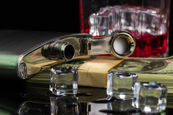 Stainless steel flask liquor alcohol and ice on table with glass - 写真・画像