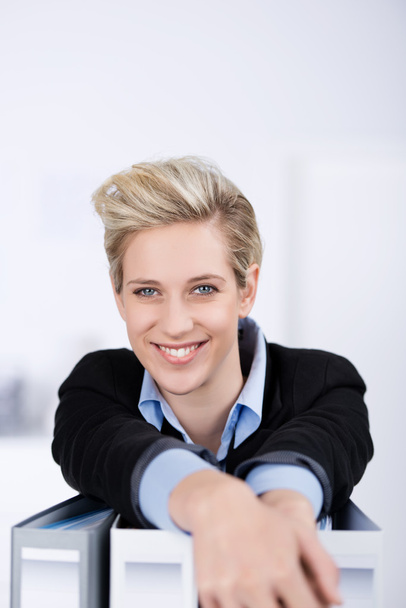 Smiling Businesswoman With Ring Binders At Desk - Foto, afbeelding