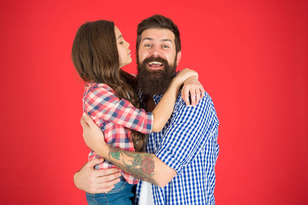 Family values concept. Family bonds. Friendly relations. Father hipster and his daughter. Sweet hug. Man bearded father and cute little girl daughter on red background. Celebrate fathers day - Fotografie, Obrázek