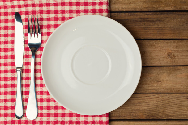 Empty plate with fork and knife on tablecloth - Foto, Imagem