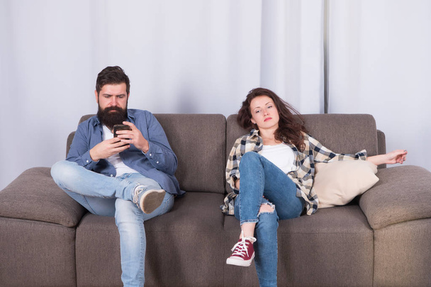 Mobile gadget dependence. Man bearded hipster play smartphone while girlfriend relaxing near. Internet surfing and social networks. Mobile internet addiction. Husband addicted internet online games - 写真・画像
