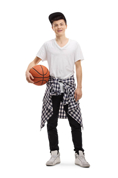 Full length portrait of a male teenager posing with a basketball isolated on white background - Photo, Image