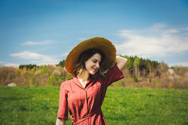 Hermosa chica en vestido rojo y sombrero tienen un tiempo despreocupado en el aguamiel
 - Foto, imagen