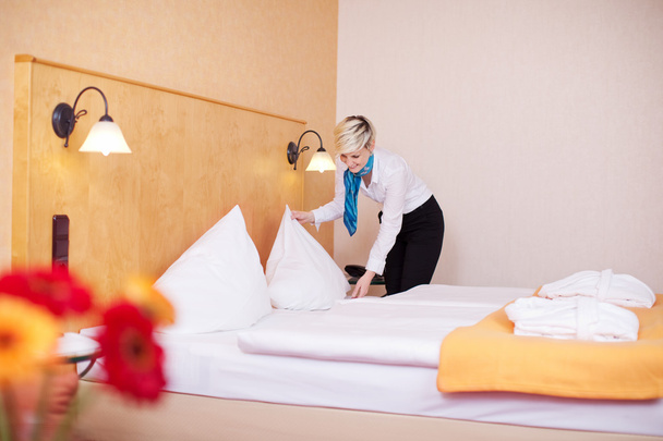 Housekeeper Making Bed In Hotel Room - Foto, afbeelding