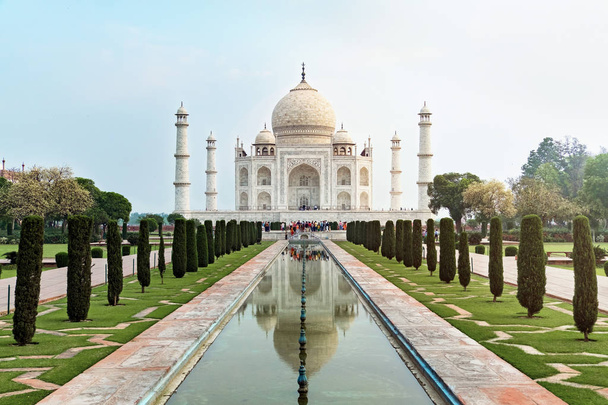 タージ・マハルの正面の眺めは、インドのウッタル・プラデーシュ州アグラのヤムナ川の南岸にある象牙の白い大理石の霊廟である反射プールに反映されています。世界の七不思議の一つ. - 写真・画像
