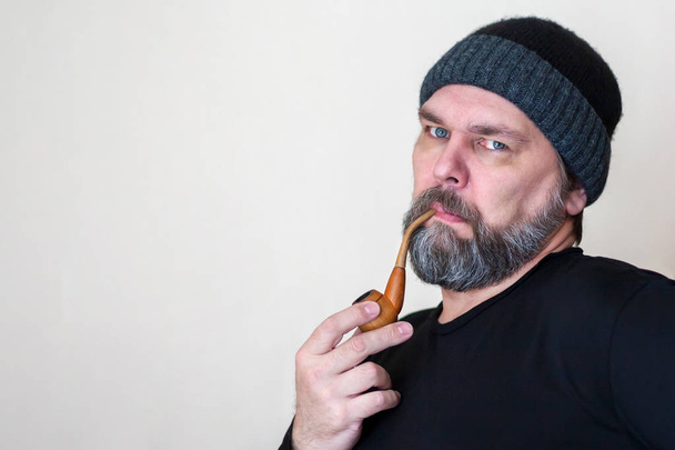 Serious Mature middle-aged man with a beard, Smoking a pipe, loo - Zdjęcie, obraz