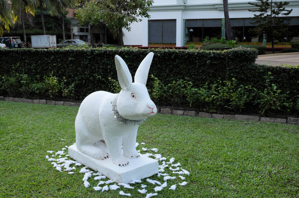 escultura decorativa de jardín de un conejo, conejo blanco en un césped verde, decoración festiva
 - Foto, Imagen