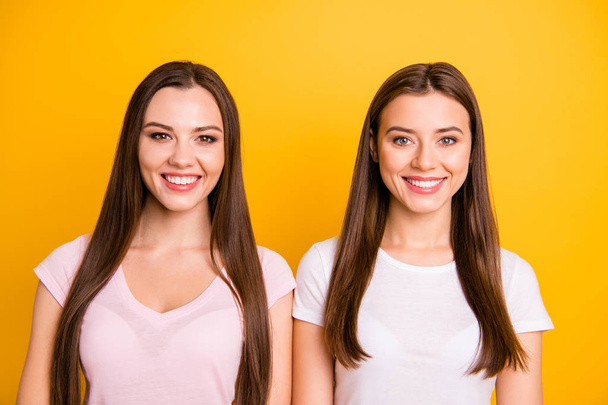 Close up photo two people beautiful funny funky she her models chic ladies perfect teeth pretty appearance long straight hairdo wearing white pink casual t-shirts isolated yellow background - Foto, imagen
