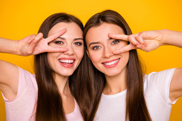 Close up photo of charming cute lovely best fellows fellowship make v-signs near face feel glad excited candid travel have free time weekends wear pastel clothing isolated on vibrant background - Fotoğraf, Görsel