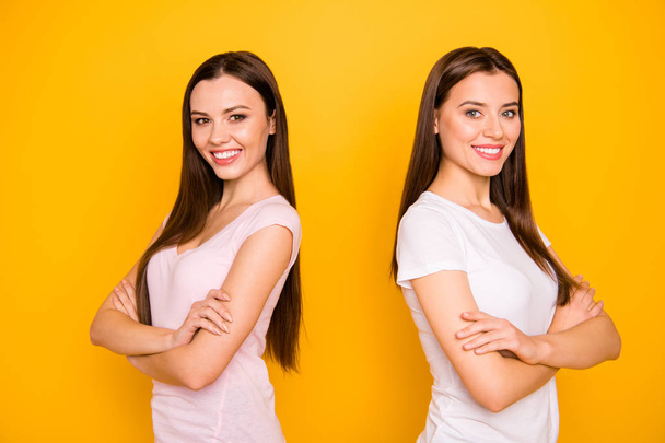 Portrait of nice cute charming lovely attractive cheerful cheery straight-haired ladies standing back to back isolated over bright vivid shine background - Foto, imagen