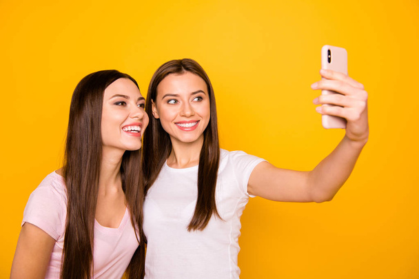 Portrait of nice cute charming lovely sweet winsome attractive cheerful cheery straight-haired girls taking making selfie free time isolated over bright vivid shine background - Fotó, kép