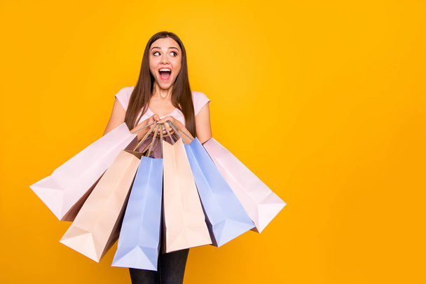 Portrait of her she nice cute charming lovely winsome attractive cheerful cheery straight-haired girl holding in hands new bags purchase win winner isolated on bright vivid shine yellow background - Photo, Image
