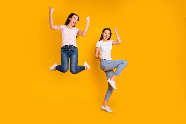 Full length body size view portrait of nice charming lovely attractive cheerful overjoyed satisfied slim fit thin straight-haired girls having fun rejoice isolated on bright vivid shine yellow - Fotó, kép