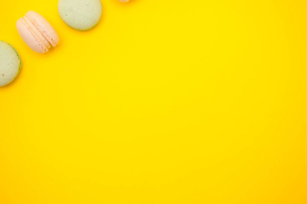 Top view of colorful macaron or macaroon on yellow background - 写真・画像
