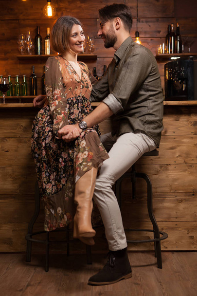 Stylish young couple on a night out in a vintage pub and holding hands - Photo, Image