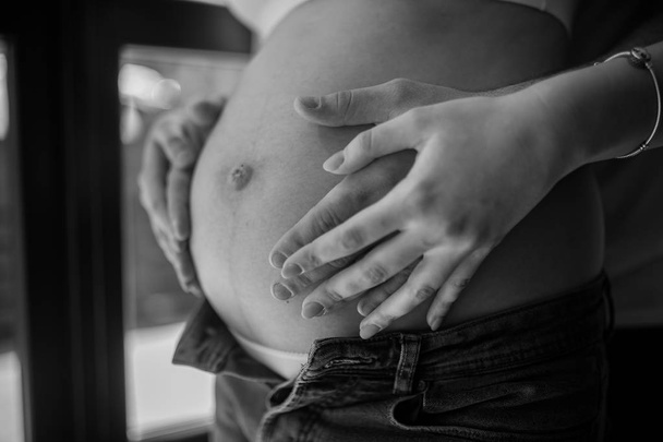 Les mains masculines et féminines embrassent le ventre de la femme enceinte
. - Photo, image