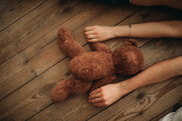 Male and female hands hold a teddy bear. - Photo, Image