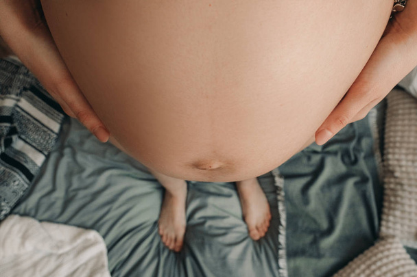 Zbliżenie brzuch stojącej kobiety w ciąży. - Zdjęcie, obraz