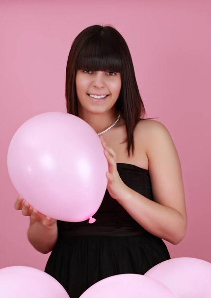 linda chica caucásica sosteniendo un globo rosa
 - Foto, Imagen