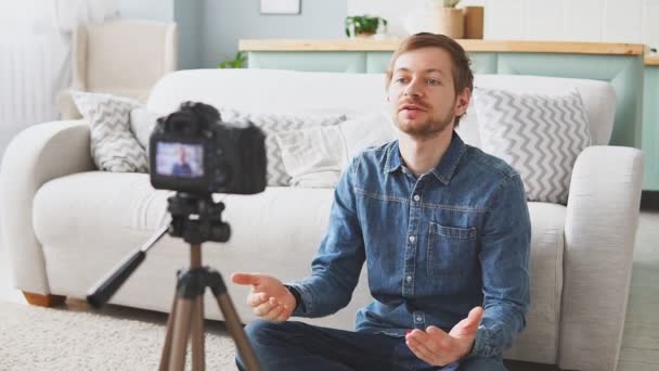 Νεαρός blogger τραβάει βίντεο με τον εαυτό του χρησιμοποιώντας κάμερα σε τρίποδο, δημιουργία περιεχομένου για τα social media, σύγχρονη τεχνολογία και blogging freelance work concept - Πλάνα, βίντεο