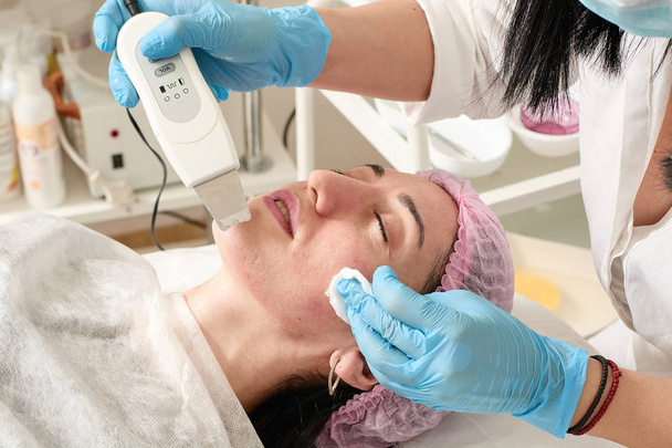 Młoda kobieta w salonie piękności robi peeling ultradźwiękowy i oczyszczanie twarzy. - Zdjęcie, obraz