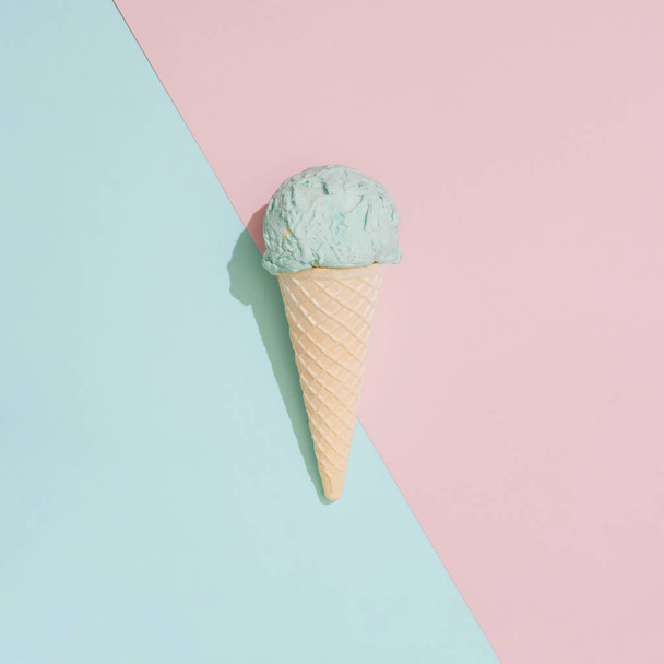 Ice cream on pastel pink and blue background. Minimal summer food concept - 写真・画像